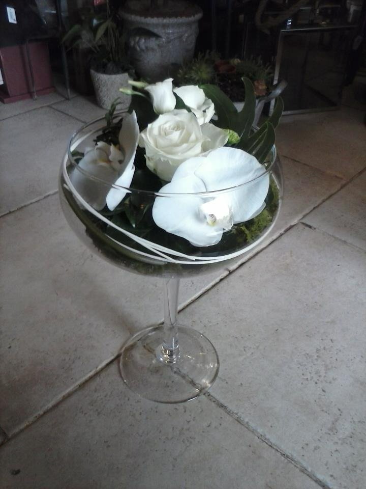 Composition florale blanche avec orchidée et rose dans une coupe en verre
