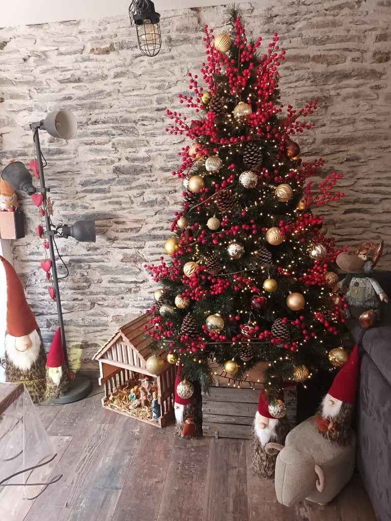 Sapin de Noël décoré avec roses de Noël et baies rouges